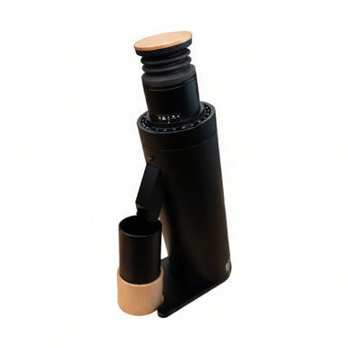 Black coffee grinder with wooden top and base on a wooden surface