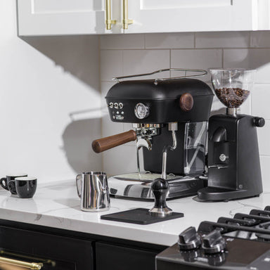 Black espresso machine with a grinder on a kitchen counter.