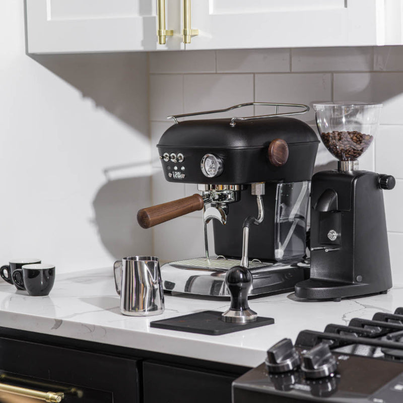 Black espresso machine with a grinder on a kitchen counter.
