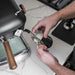 Person using a manual espresso machine with a focus on the portafilter and hand action.