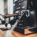 Espresso machine on a wooden surface with a blurred background