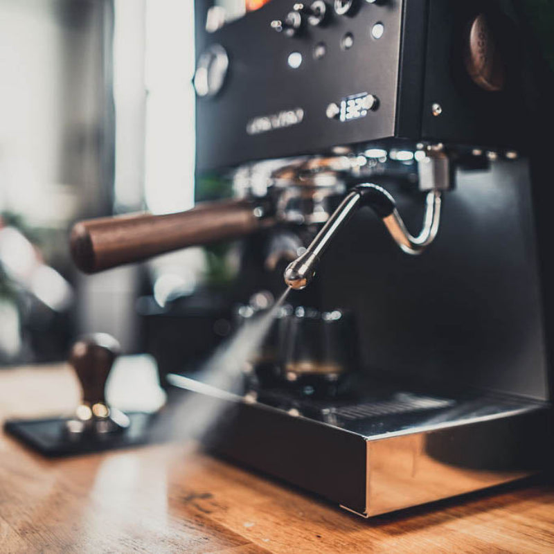 Espresso machine on a wooden surface with a blurred background